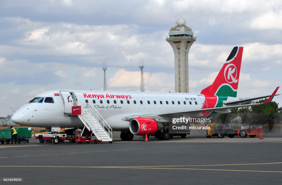Kenya Airways plane on the tarmac at Jomo Kenyatta International Airport Nairobi in front of the control tower